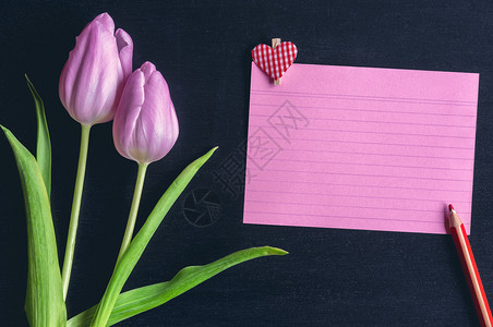 有粉红色郁金香的贺卡想法红色的笔记本纸有条纹木铅笔和有心的木片黑色背景图片
