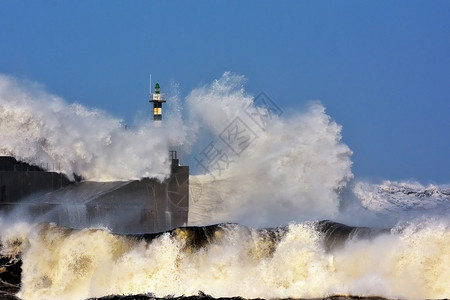 灯塔背景在西班牙的阿斯图里亚岛横跨灯塔和圣埃斯特班码头的暴风波背景
