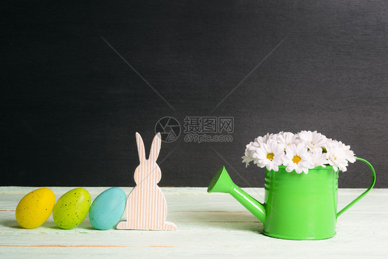 在阳光明媚的一天东面画鸡蛋靠着一只木兔绿水罐里满白菊花桌子上墙黑图片