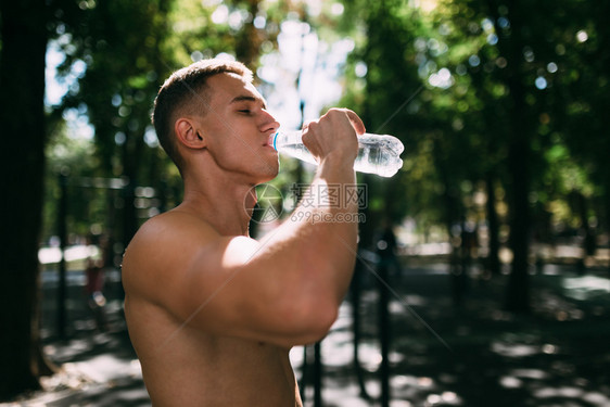 运动员用瓶子喝水户外健身图片