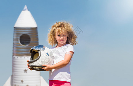 着玩具火箭梦想成为太空人金发小女孩的肖像画梦想成为太空人图片素材