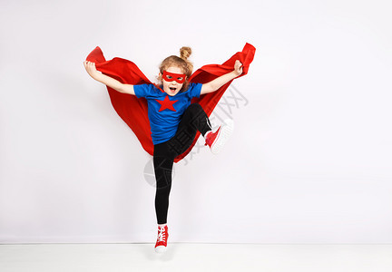 六岁金发女孩穿得像超级英雄在家里玩耍白墙在背景上六岁金发女孩穿得像超级英雄在家里玩耍图片