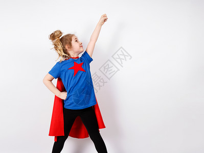 六岁金发女孩穿得像超级英雄在家里玩耍白墙在背景上六岁金发女孩穿得像超级英雄在家里玩耍图片
