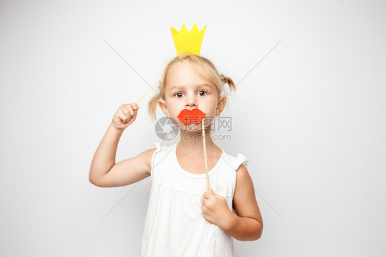 穿着纸冠和红嘴唇的美丽小女孩穿着纸冠和红嘴唇图片
