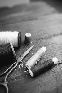 缝纫配件线剪刀针头在木制桌上的针头黑白相片缝纫和概念配件线木制桌上的针头黑白相片缝纫和概念图片
