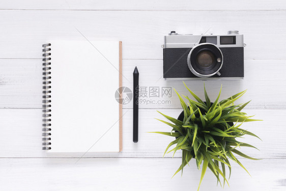 白色办公桌木背景有模拟笔记本和反光照相机图片