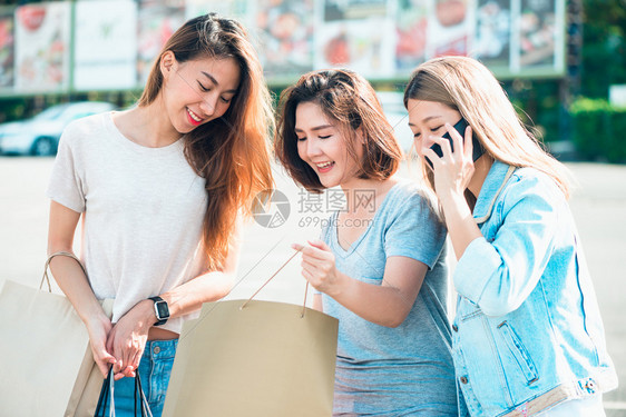 购物与旅游概念一群快乐的亚洲朋友女在城市购物的照片图片