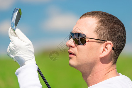 一个高尔夫球手在看俱乐部的近视肖像图片