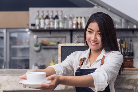 一位女服务员手上握着一杯咖啡图片