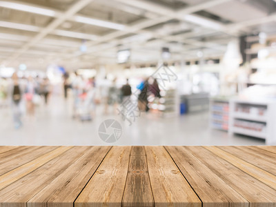 在百货公司背景中模糊的视野褐色木质桌可用于显示或调制您的产品模拟图片