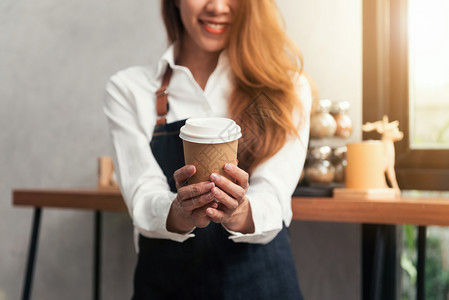 一位女服务员手上握着一杯咖啡图片