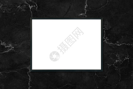 在室内黑大理石墙背景上挂着的模拟空白海报图片框可用作装配产品显示和设计关键视觉布局的模型图片