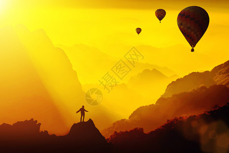 年轻旅行者站在山顶幻想的日落与热气球旅行的生活方式成功概念冒险在户外积极度假幸福的自由情绪图片