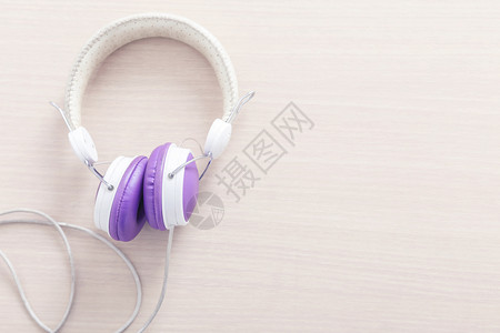 木桌上有紫色和白耳机可自由背景空间音乐放松概念图片