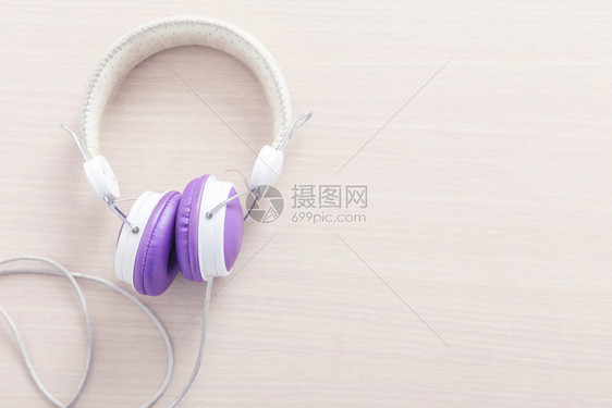 木桌上有紫色和白耳机可自由背景空间音乐放松概念图片