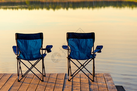 黎明时湖附近一个木制码头上两张椅子没有人坐的椅子图片