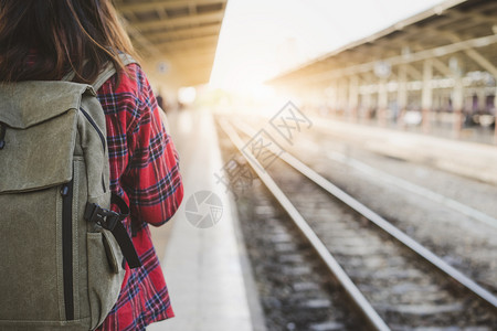 独自在火车站平台上行走背着包在火车站等旅行的年幼妇女暑假旅行或年轻游观光者概念图片