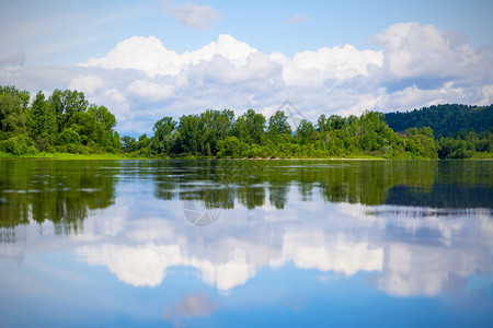 美丽的风景蓝色天空和白的云反映在清澈的河水中山湖的木质水面夏季的雨林风景美丽的蓝色天空和白云反射着蓝色的天空和白乌云图片