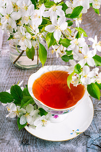 茶杯用鲜花供应早餐茶杯用木桌和苹果花供应图片