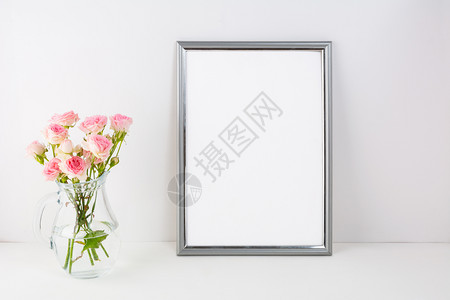 带有粉红色玫瑰的银框架模型肖像或海报白框架模型用于展示艺术作品的空白框架模型银色框架模型带有粉红色玫瑰图片