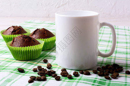 白色杯子模型绿餐巾纸上的巧克力松饼空白杯子模型用于设计演示白色杯子模型绿上巧克力松饼图片