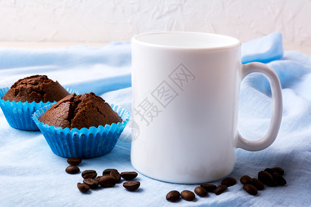 白色杯子模型配有咖啡豆和两个巧克力松饼空杯子模型用于设计演示图片