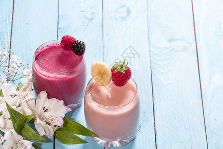 两杯新鲜健康水果冰淇淋早餐桌加一杯新鲜香蕉和草莓冰淇淋一份带草莓和野图片