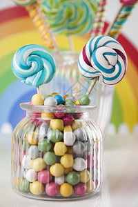 口香糖球上桌的罐子中彩色糖果棒和口香球中的玻璃罐子图片