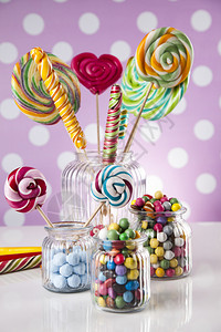 口香糖球上桌的罐子中彩色糖果棒和口香球中的玻璃罐子图片