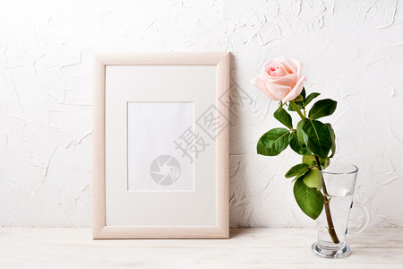 木制海报框架模型用玻璃杯中的粉红玫瑰制成空框模型用于演示设计现代艺术的模板框架木制模型用粉红色玫瑰制成图片