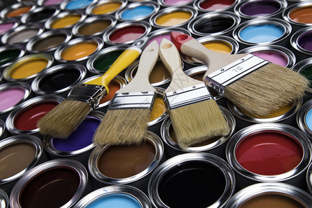 含彩色的罐子上油漆刷的含彩色的油漆刷子罐上的图片