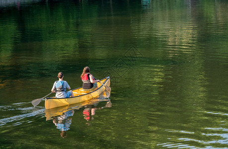 夫妇在湖边划独木舟图片