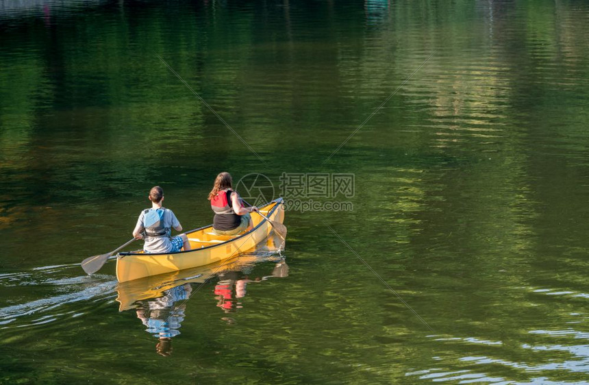 夫妇在湖边划独木舟图片