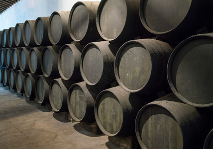 堆叠的橡木桶或圆沿磨旧雪利或港口的红酒墙一排堆叠的木制红酒桶雪利老化的木制红酒桶图片