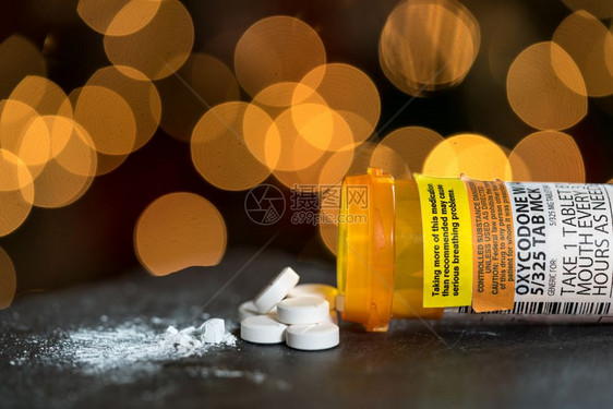 氧科酮类阿片氧科酮是一系列类阿片痛致死药的通用名称氧科酮片和药的处方瓶和丸放在餐桌上底有圣诞树灯氧科酮类阿片的宏图片
