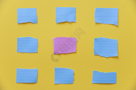 蓝色和粉红纸笔撕碎成片放在黄色桌子上图片