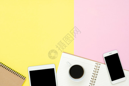 办公桌工作空间平的办公空间白笔记本页咖啡杯和模拟糊面背景的电话平板粉色黄彩背景空间概念办公桌工作空间平的办公空间图片