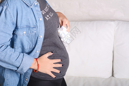 孕妇将靴子放在腹部图片
