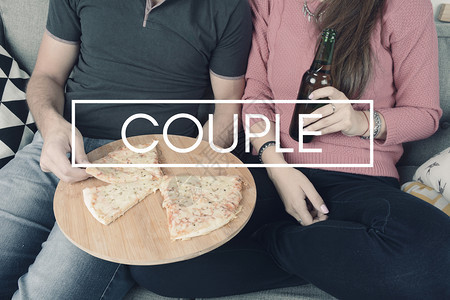 美丽的年轻夫妇喝着啤酒吃着披萨在室内关系和约会概念图片