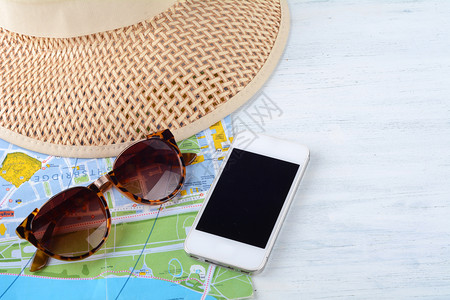 一张带太阳镜智能手机和帽子的旅行概念图片