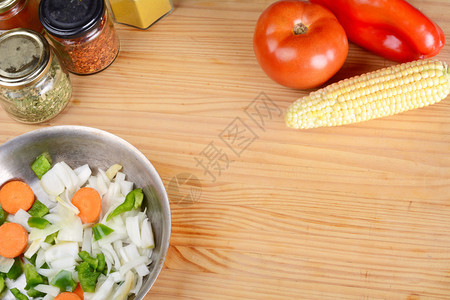 在木制桌上做饭的蔬菜和调味料图片