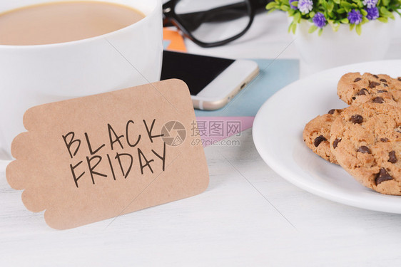 黑色星期五的纸卡和黑色星期五的纸卡文字和含手机的咖啡用白色木本背景黑色星期五的纸卡文字图片