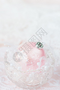 美丽的圣诞节装饰一个大粉红圣诞节舞会在光底水晶花瓶中带有白丝和珍珠并有复制空间图片