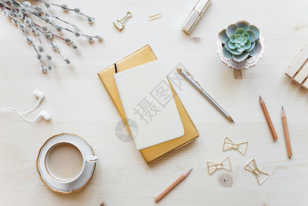 金色调的女家庭办公桌工作空间带有笔记本咖啡杯和装饰轻木背景复制空间平面最高视图图片