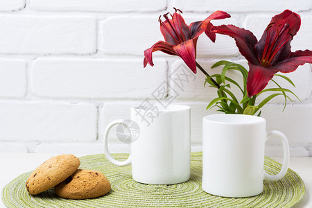 两杯白咖啡装黑色布贡迪百合和饼干空杯装设计宣传图片