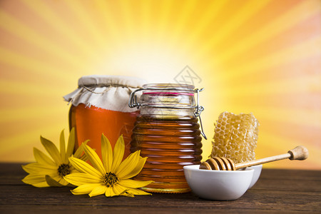 蜂蜜在罐子中的花朵甜的蜂蜜图片