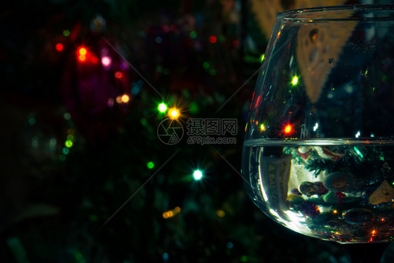 a杯水在抽象背景上带有bokeh灯光图片