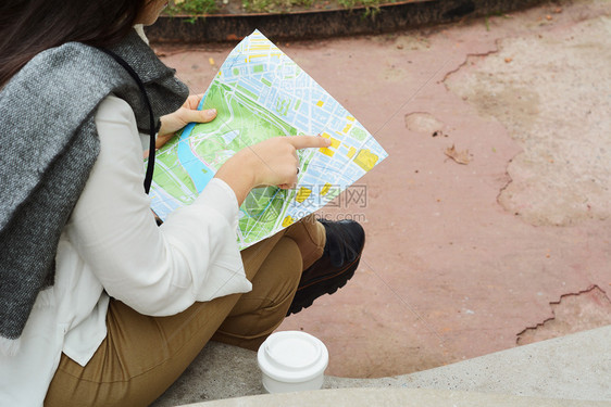 身着温暖衣服在她手中的深思熟虑年轻旅游女孩户外行概念图片