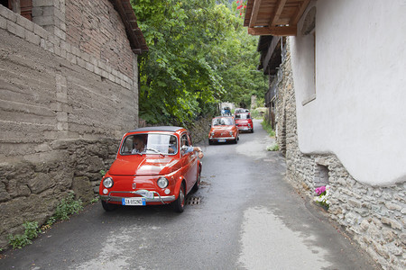 在狭窄的意大利街上停放50辆老式汽车背景图片