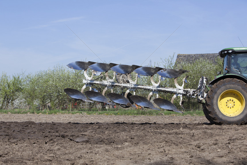 在阳光明媚的日落时在靠近特勒支的春天在乌黑地的dutch田地上在拖拉机后面的犁地上在乌德列支附近的春光下图片